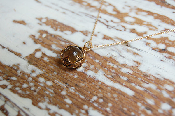 encased glass ball pendant | bronze