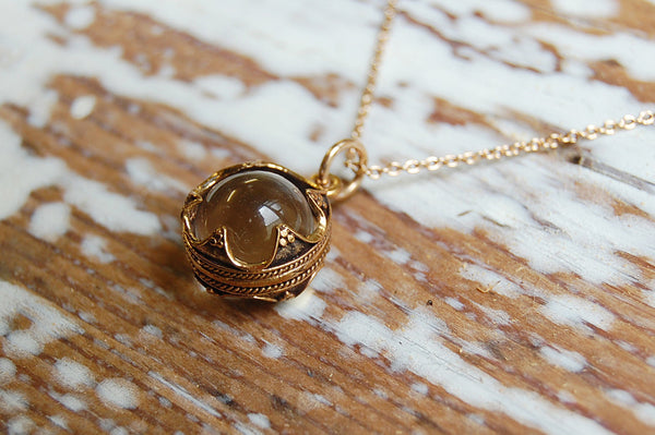 encased glass ball pendant | bronze